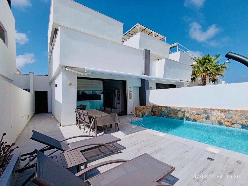 a villa with a swimming pool and a house at Casa Kempie in San Javier