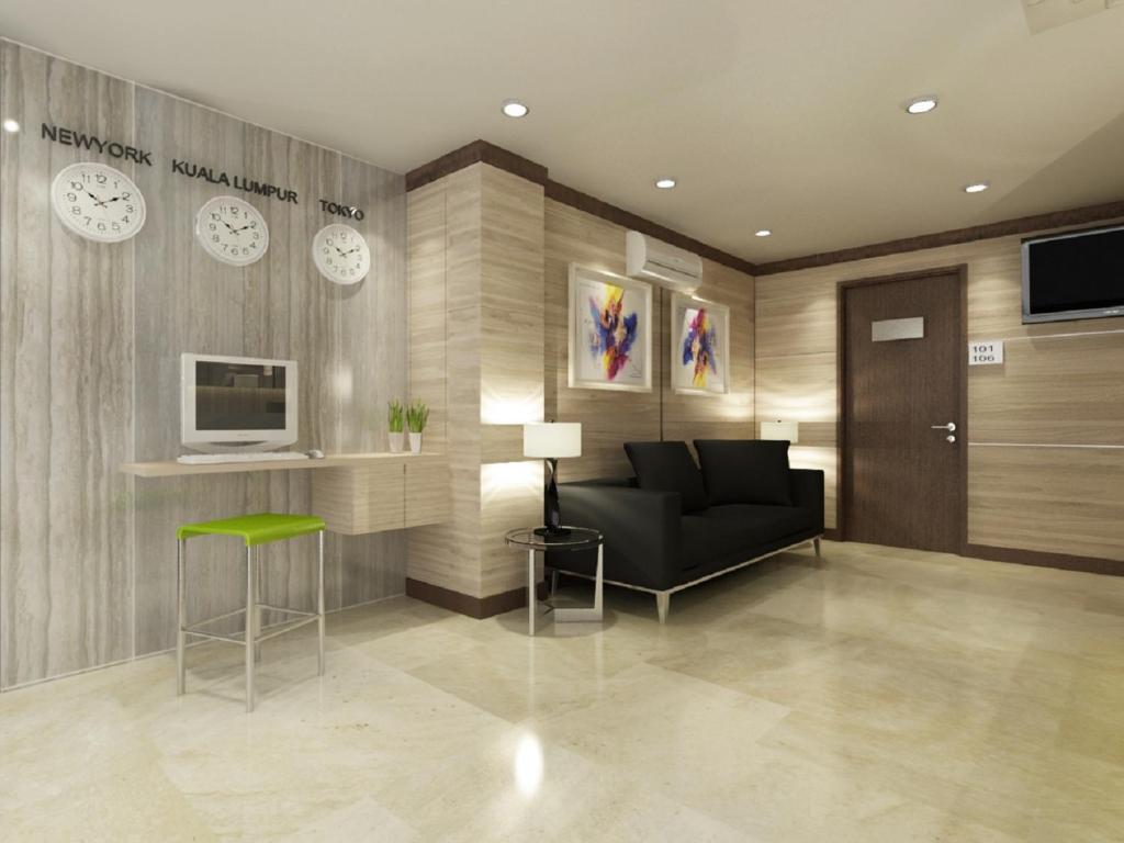 un vestíbulo con sofá, TV y relojes en Grand Hallmark Hotel - Johor Bahru, en Johor Bahru