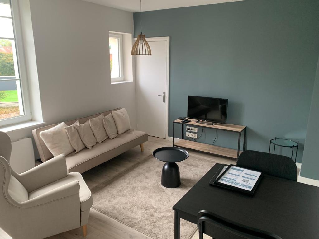 ein Wohnzimmer mit Couch und Tisch in der Unterkunft Léon et Victor in Tavaux