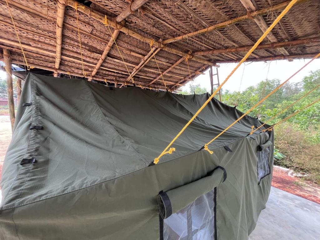 a green tent hanging from a roof at Mantan Stay in Tadri