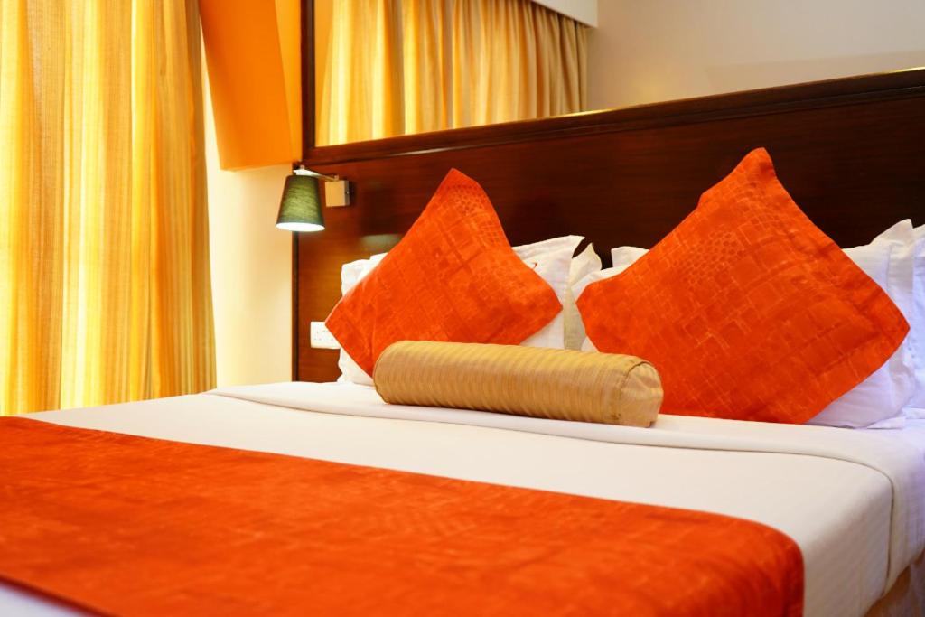 Habitación de hotel con cama con almohadas de color naranja en Sironka Mara, en Masai Mara