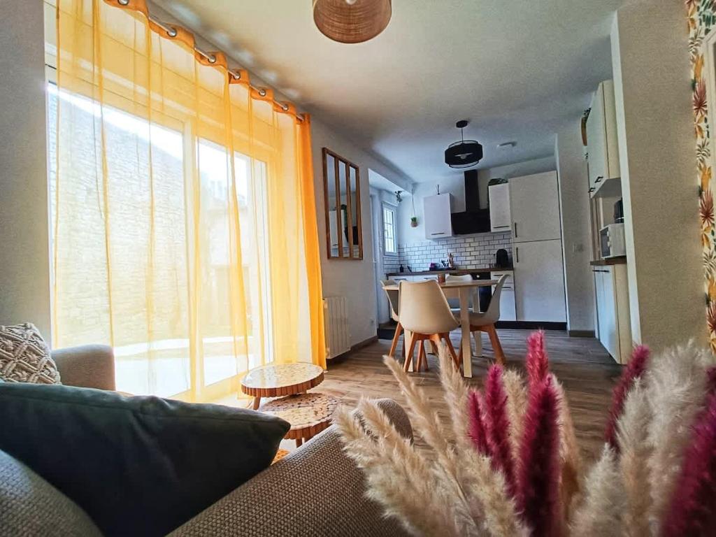 a living room with a couch and a dining room at Le Rez des Arcades - T2 en RDC hypercentre in Carentan