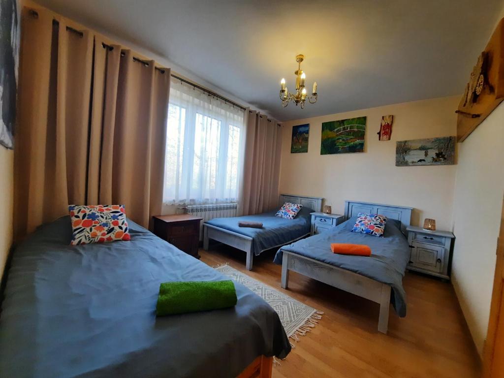 a bedroom with two beds and a couch at Gościna U kowala in Lachowice