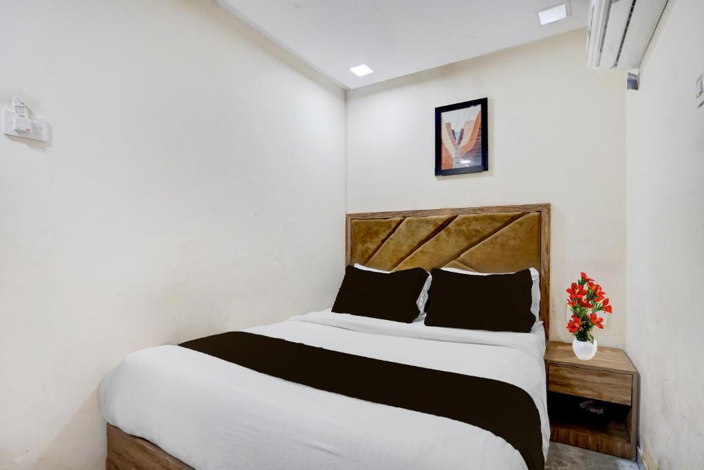 a bedroom with a bed and a vase of flowers at Hotel O Beverly Plaza Kurla in Mumbai