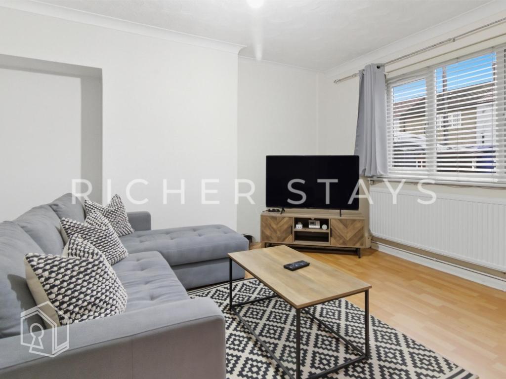 ein Wohnzimmer mit Sofa und Fernseher in der Unterkunft Rustic 3BR house in Tilbury, Garden and Parking in Tilbury