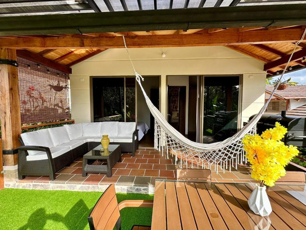 a porch with a hammock on a patio at Magnífica Cabaña en Pony Parque Mesa de los Santos in Piedecuesta