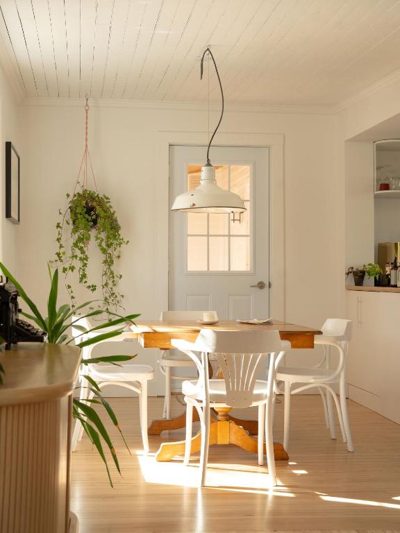 a white dining room with a table and chairs at Le Boulevard par Maison Dudley in Lac-Mégantic