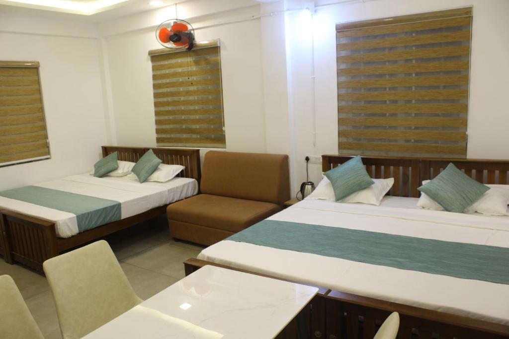 a hotel room with two beds and a chair at Skyline Inn in Anachal