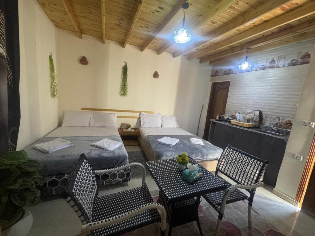 una habitación con dos camas y una mesa y sillas en Jory Studios, en Dahab