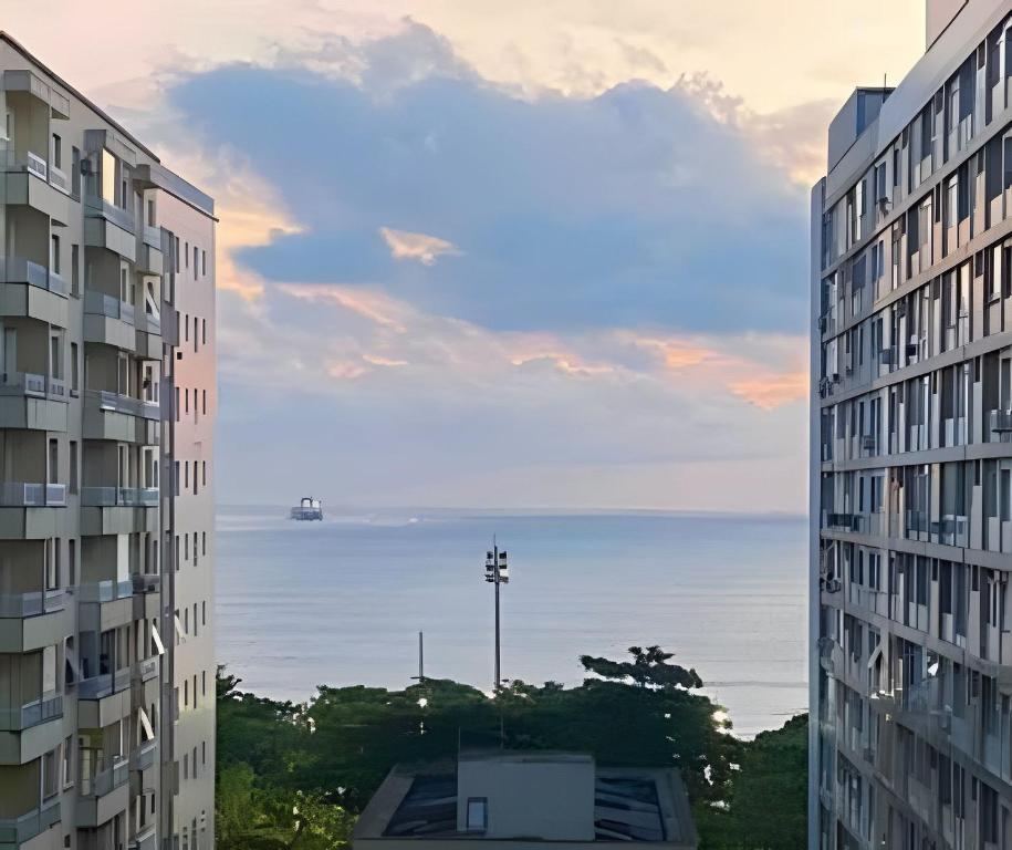 a view of the ocean from between two buildings at Lindo Sala Living com vista para o Mar in Santos