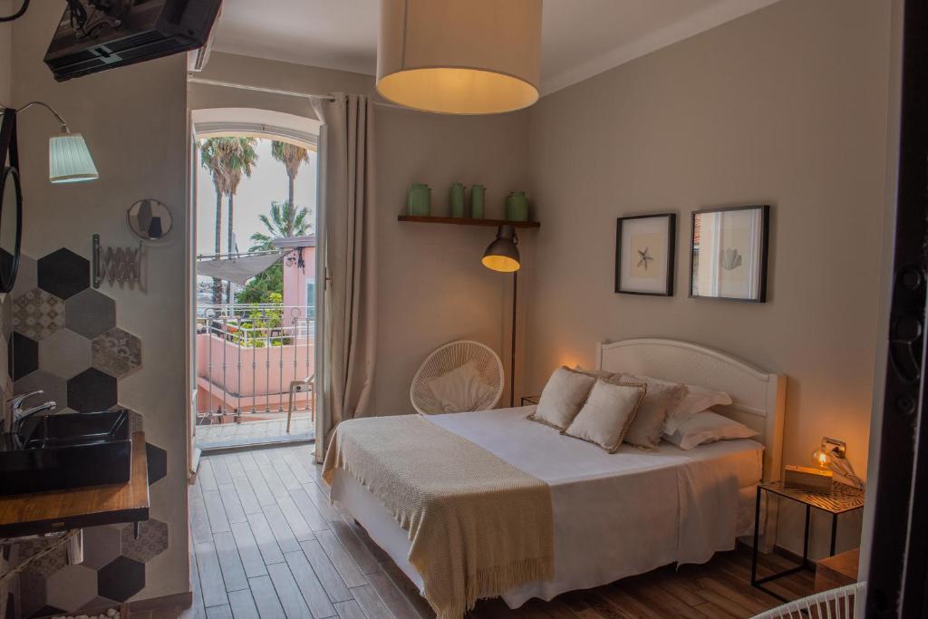 a bedroom with a bed and a door to a balcony at Fra Diavolo in Diano Marina
