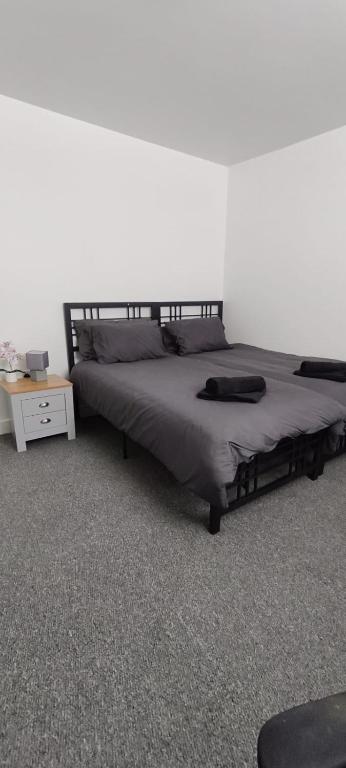 a bedroom with a large bed with a night stand at Quality Rooms in Liverpool