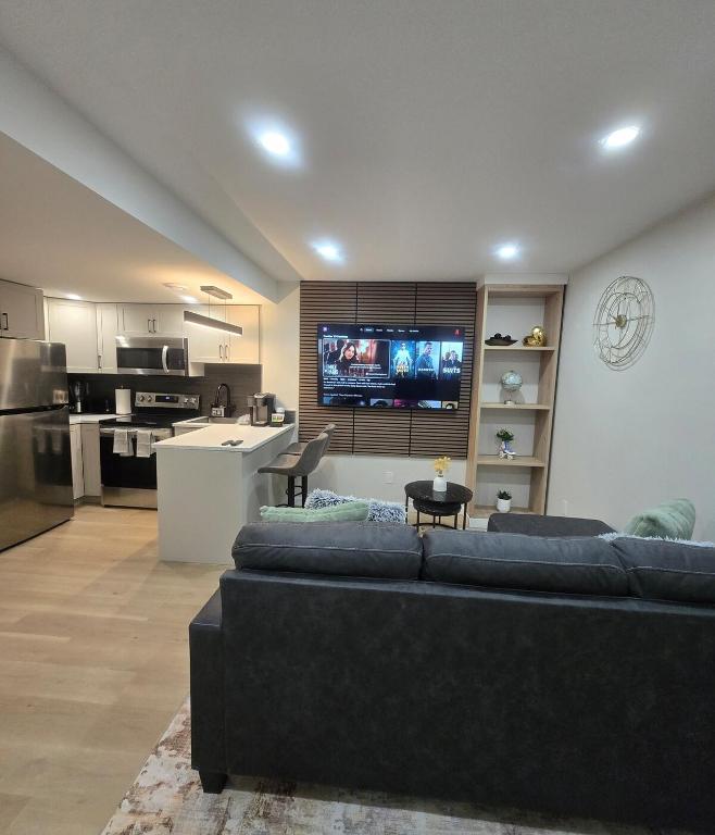 a living room with a couch and a kitchen at Rhote's Luxury Suite in Saskatoon
