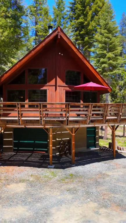 a large wooden building with a red umbrella at Little Bear Lodge, Located in Ponderosa California in Springville