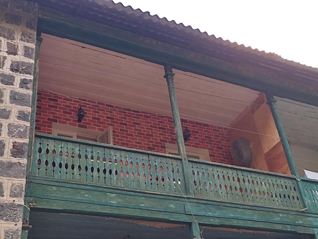a balcony of a brick building with a window at Lusin hyuratyn in Dzoraget