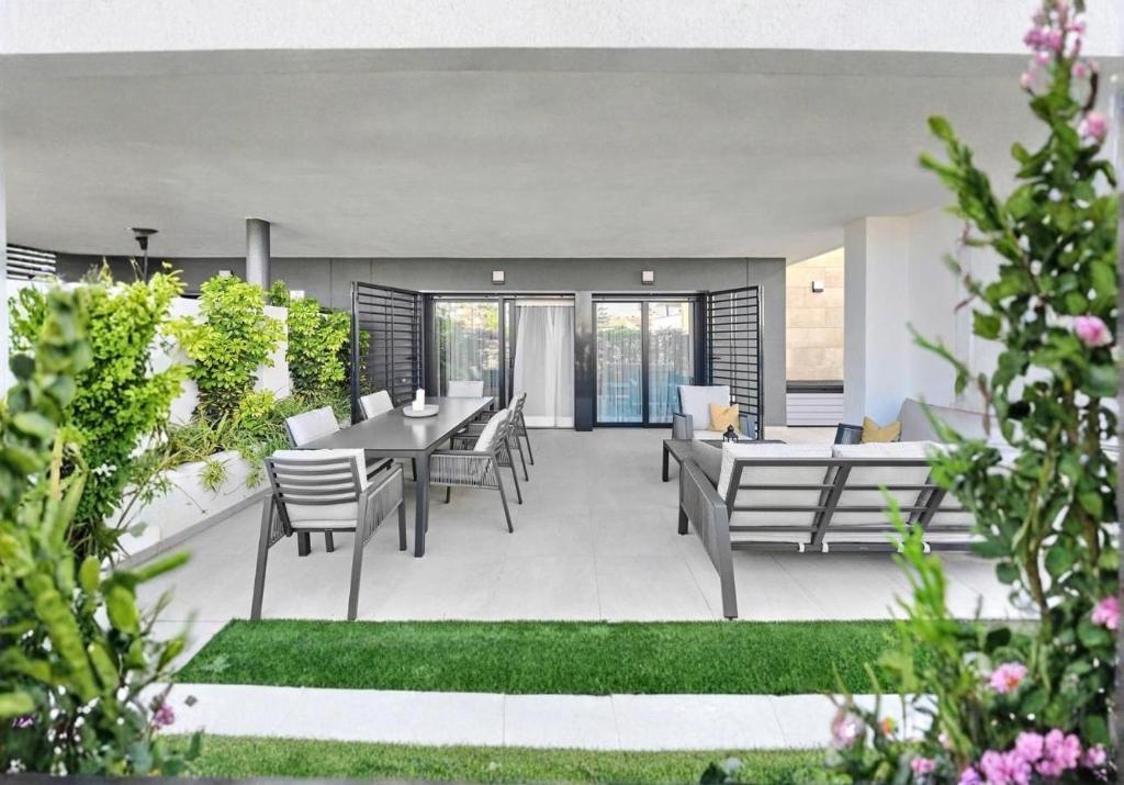 un patio avec une table et des chaises dans une cour dans l'établissement Modern and Luxury Apartment in Flamenca Village, à Orihuela Costa