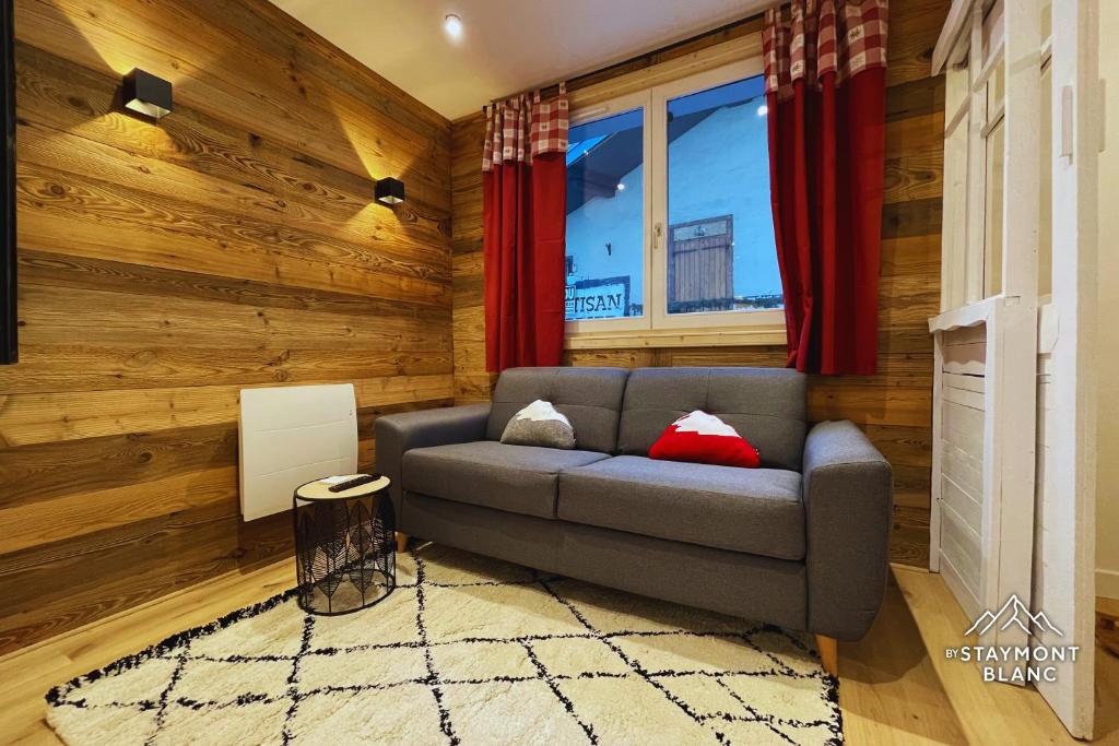 a living room with a couch and a window at Charmant 2 pièces cosy au cœur de Saint-Gervais in Saint-Gervais-les-Bains