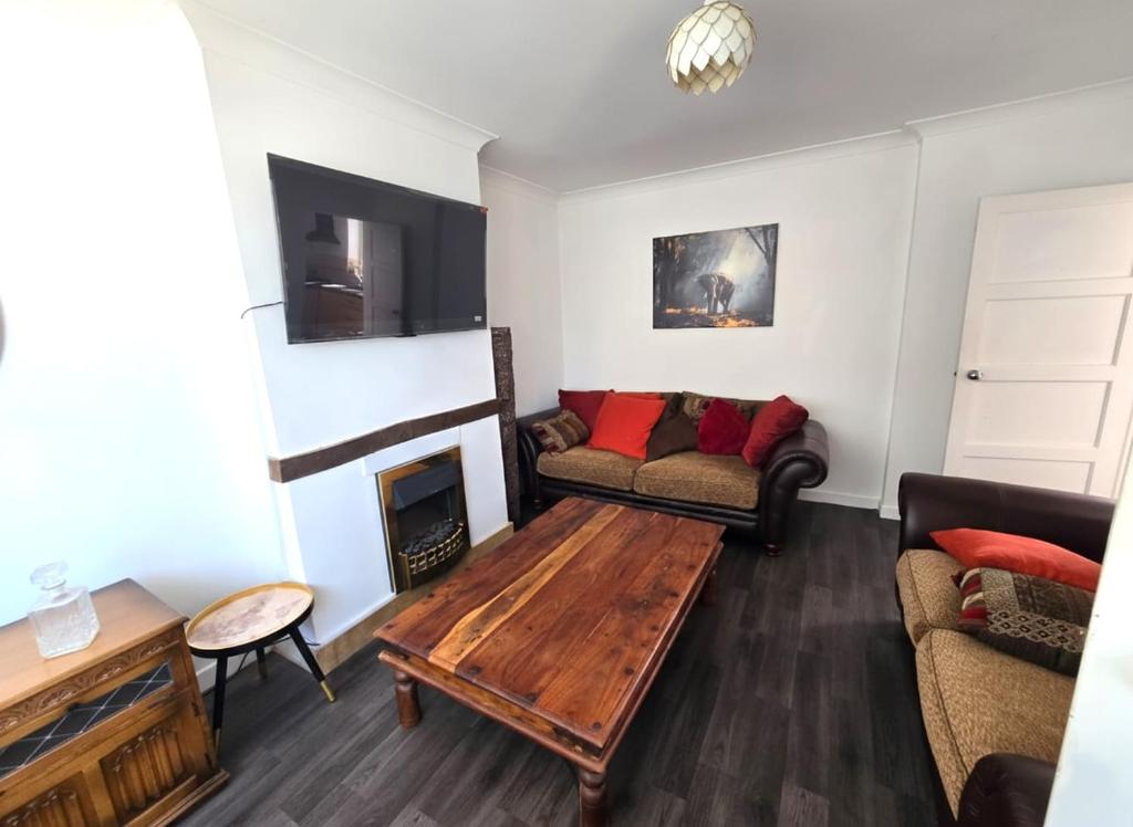 un salon avec un canapé et une table basse dans l'établissement Lovely 4 Bed Dudley Home, à Sedgley