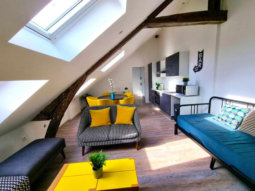 sala de estar con sofá azul y almohadas amarillas en L'appartement tranquillité, en Elbeuf