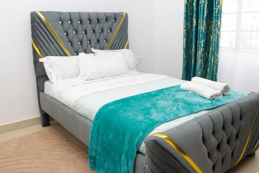 a bedroom with a bed with a blue blanket on it at The Royals in Tatu City