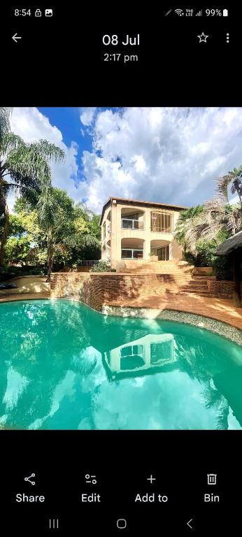 a picture of a swimming pool in front of a building at Villa La Maison in Pretoria