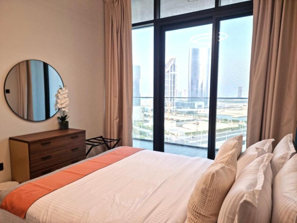アブダビにあるElegant Pool-View 1BR Near Cleveland Clinicのベッドと大きな窓のある寝室