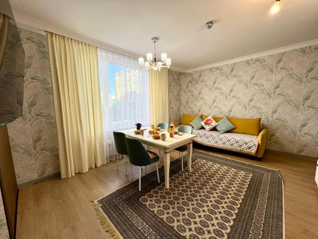 a living room with a table and a couch at Современный 3х комнатный апартаменты на Туране возле Барыс Арена in Astana