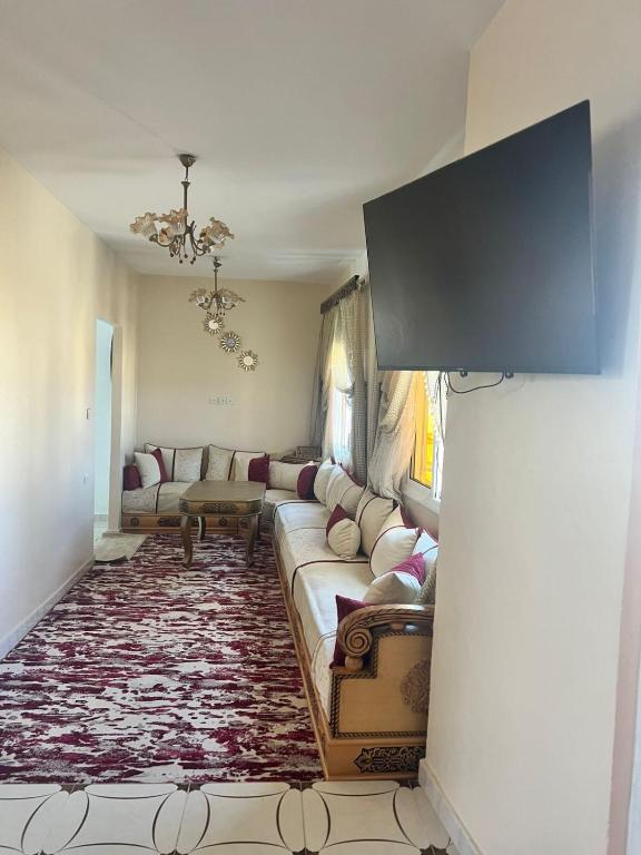 a living room with a couch and a tv at Casa Youssef 1 in Asilah