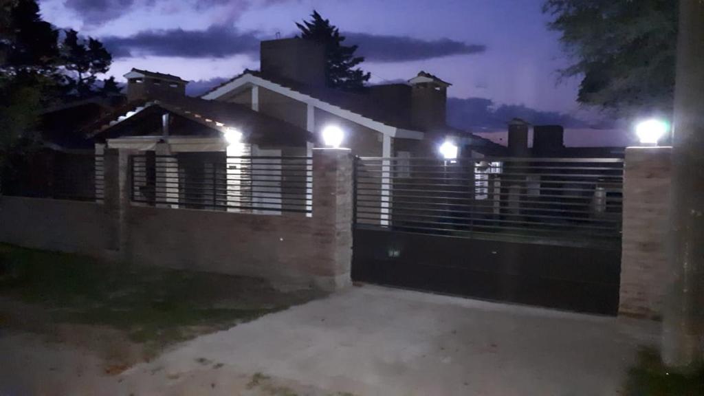 a fence in front of a house at night at Cabañas Acacias in San Antonio de Arredondo