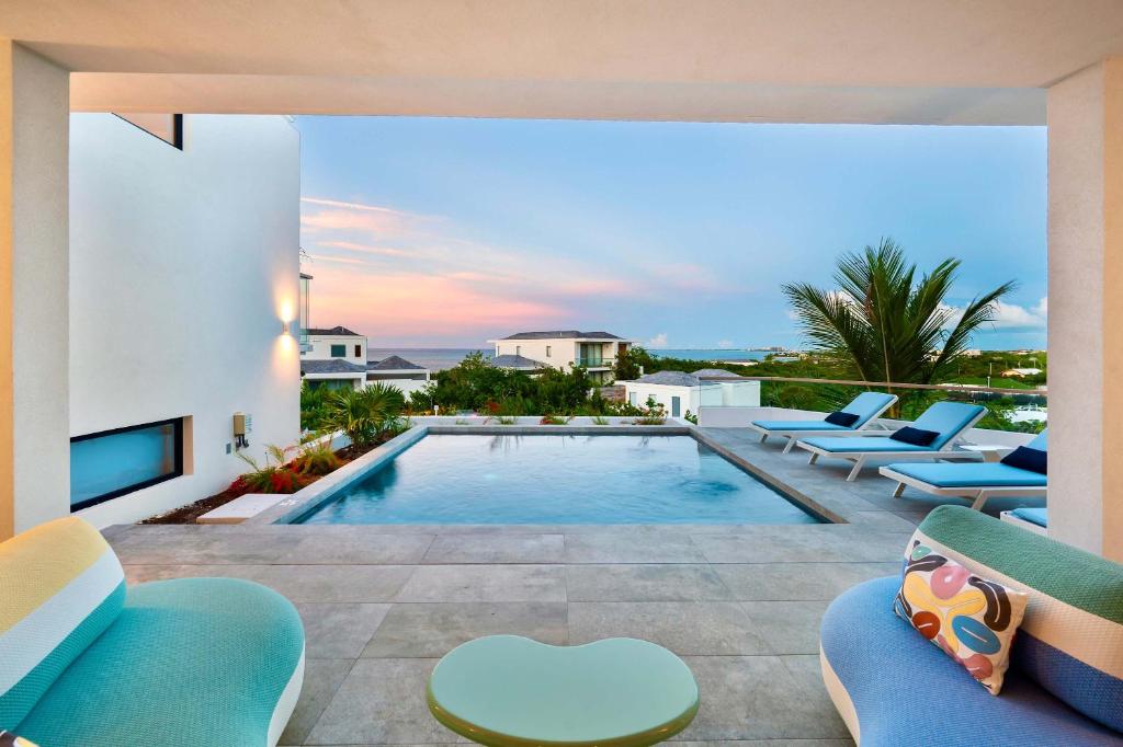 a villa with a swimming pool and lounge chairs at Villa Jupiter with Private Pool Oceanfront in Turtle Cove