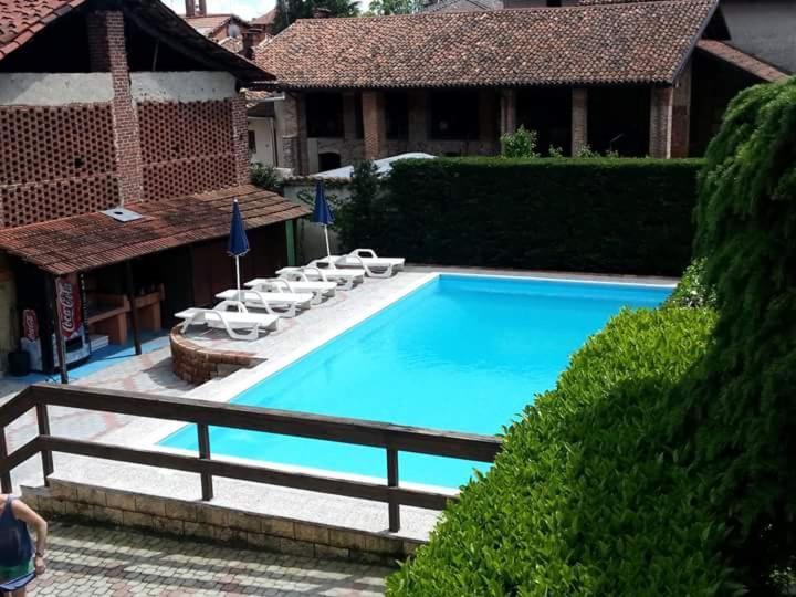 una gran piscina azul con tumbonas junto a una casa en La Cascina, en Agliè