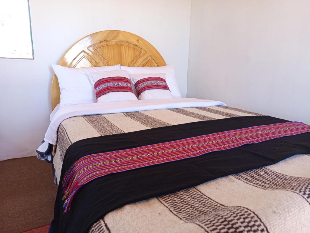 プーノにあるTiticaca Lodge Taquileの枕が2つ置かれたベッド