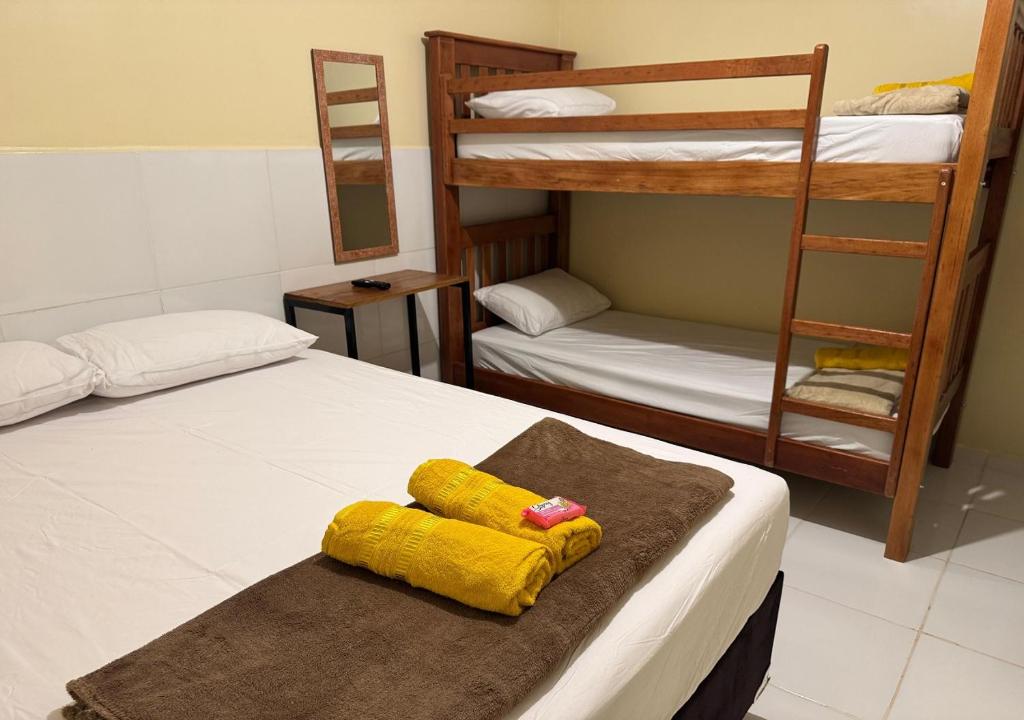 a bedroom with two bunk beds and a yellow towel at Figueiredo Hosp 3 in Presidente Figueiredo
