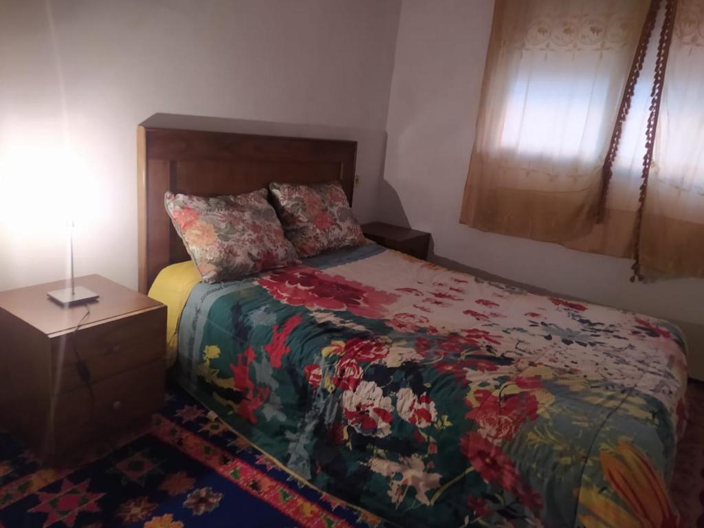 a bedroom with a bed and a lamp on a table at appartement en résidence - Bouskoura, Maroc 