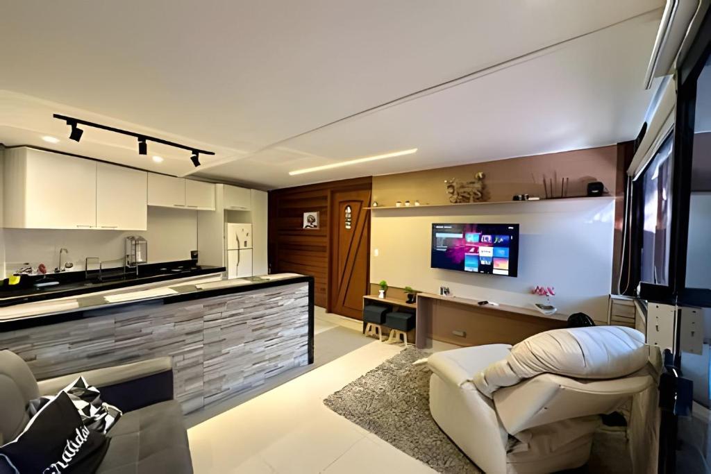 Una sala de estar con un sofá y una cocina. en Chalé Encanto, Lazer e Piscinas, en Vinicola Girardi