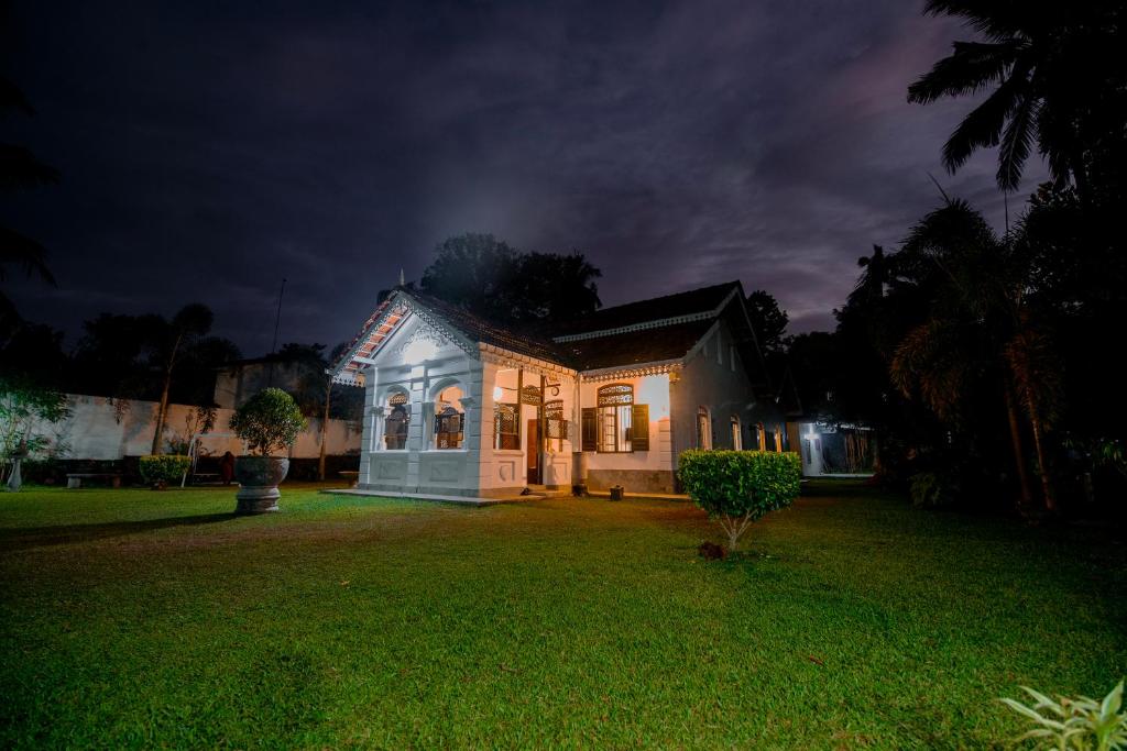 a house lit up at night in a yard at Vimansa International Meditation and Retreat Centre in Ambalangoda