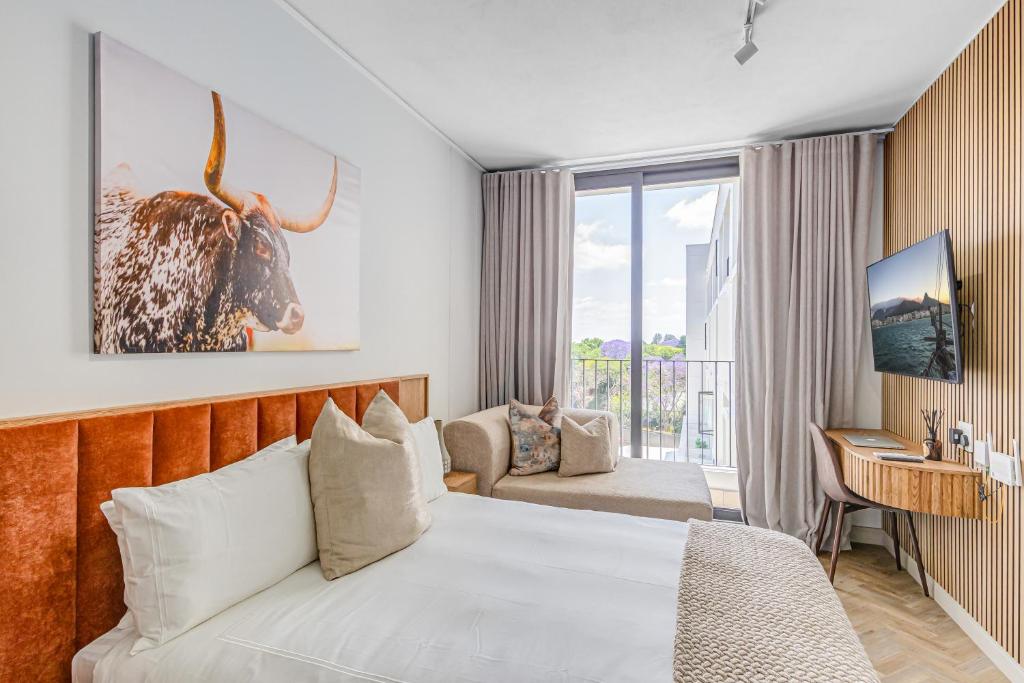 une chambre d'hôtel avec un lit et un canapé dans l'établissement One Rosebank CozyCorner, à Johannesbourg