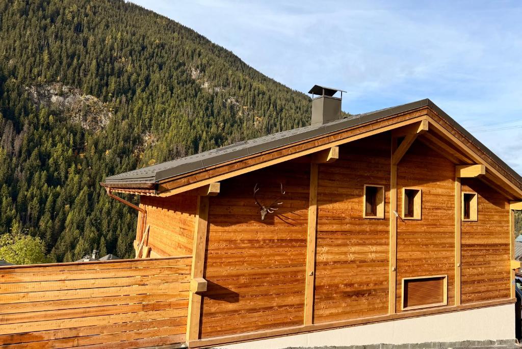 a log cabin with a mountain in the background at Chalet Perle des Alpes in Peisey-Nancroix