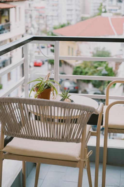 a table and chair on a balcony with plants at Downtown Hideaway in Thessaloniki