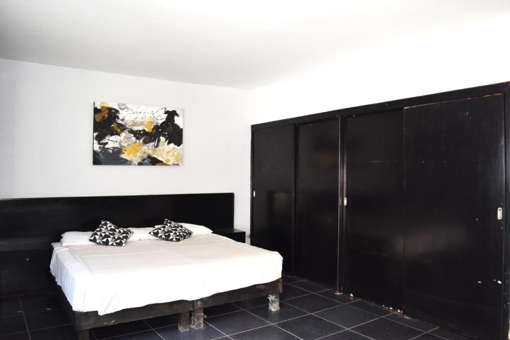 a bedroom with a bed and a large black cabinet at Bounaterra Lofts in León