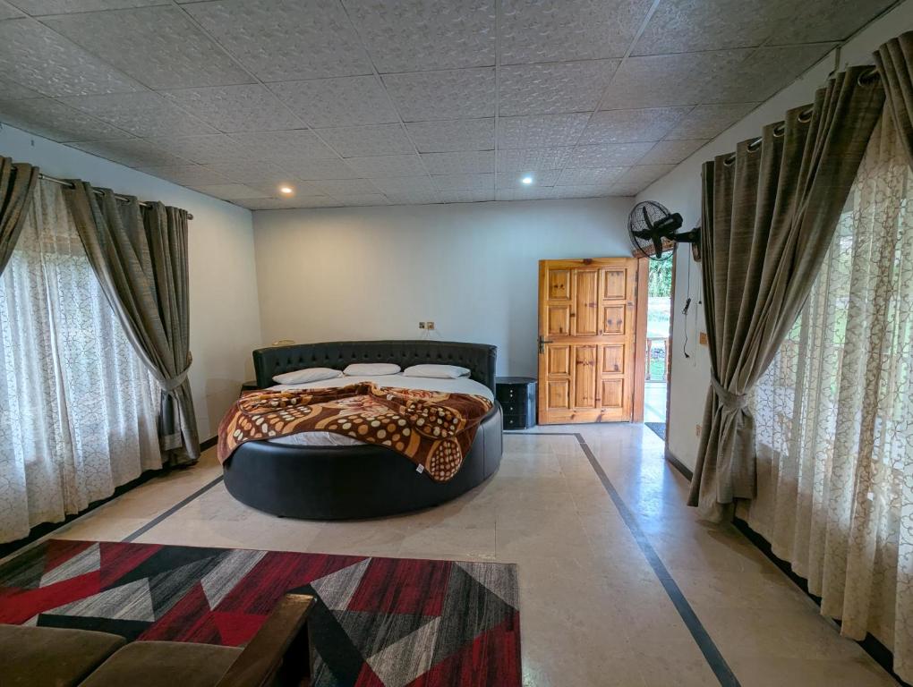 a bedroom with a bed in a room with windows at Round Bed Cottage Country Club Resorts Balakot in Pori