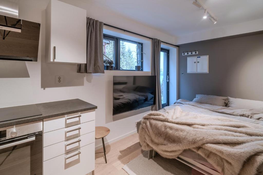 ein Schlafzimmer mit großem Bett und eine Küche in der Unterkunft Staying Apt 6 in Tromsø