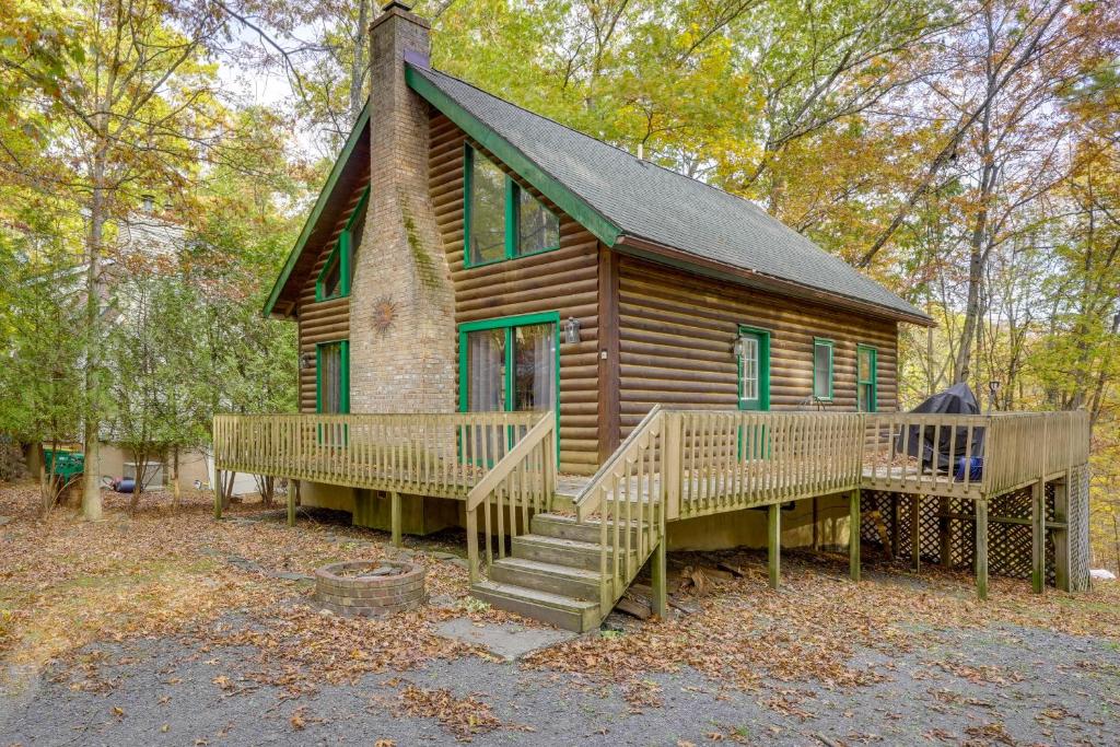 a log cabin with a porch and stairs to it at Year-Round Outdoor Adventures Poconos Hideaway in Kahkhout Mountain