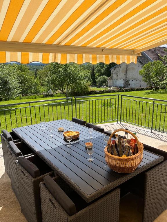 a picnic table with a basket of food on a patio at Maison de campagne Lac de Vouglans in Onoz