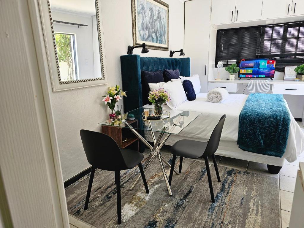 a bedroom with a bed and a table and chairs at The Little Haven in Midrand