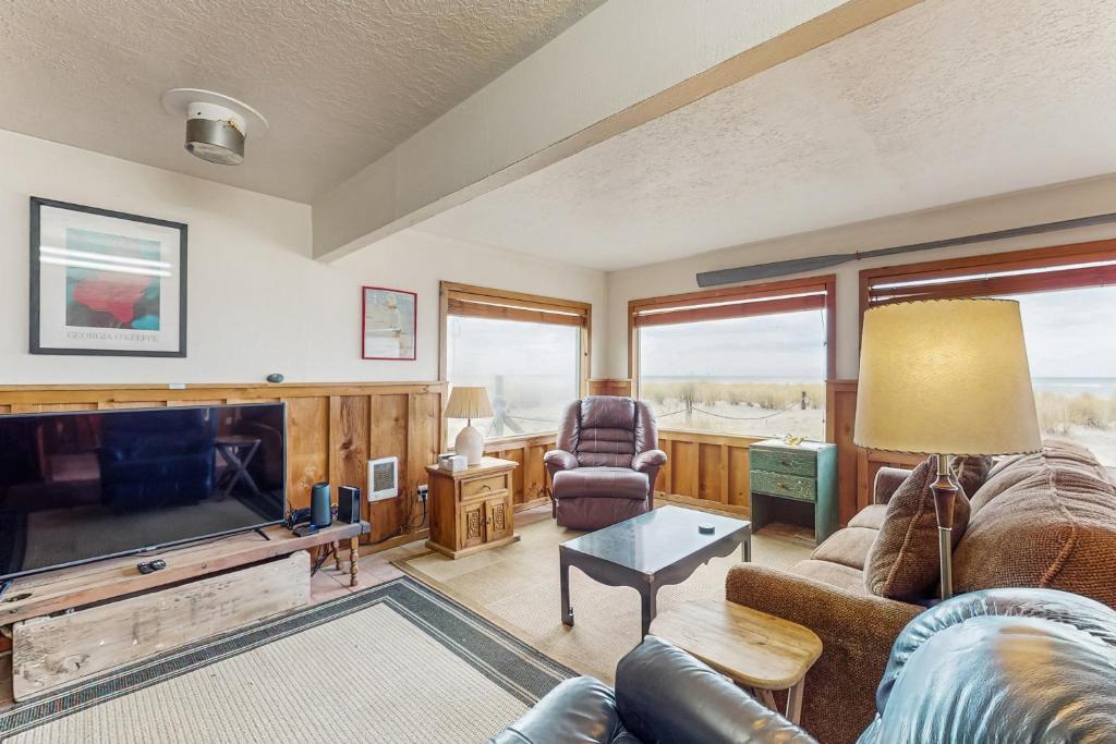 a living room with a couch and a tv at Neil's Cabin in Pacific City