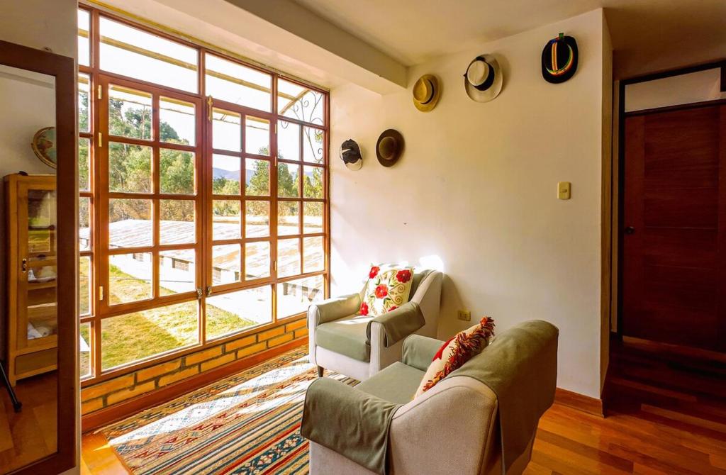 a living room with two couches and a large window at Fundo Venegas & Montoya in Jauja