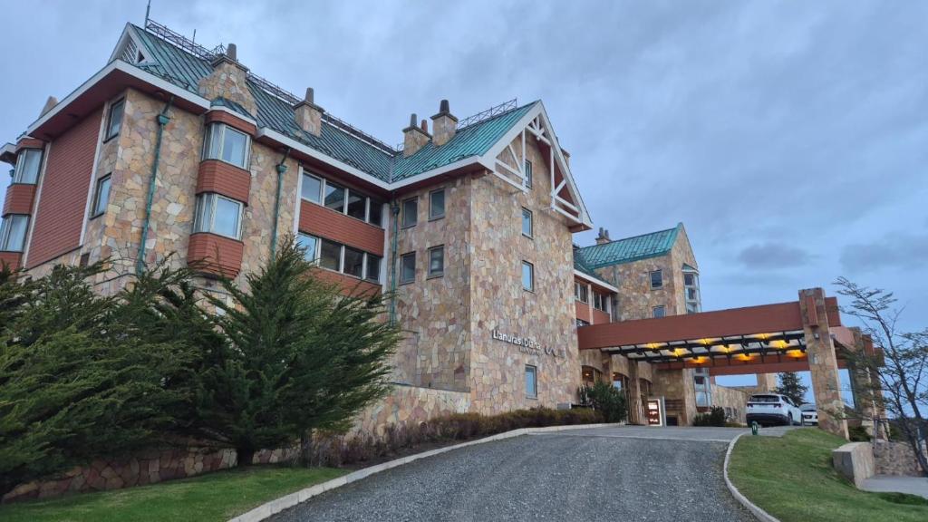 a large building with a road in front of it at Hotel y Cabañas Llanuras de Diana - Caja Los Andes in Puerto Natales
