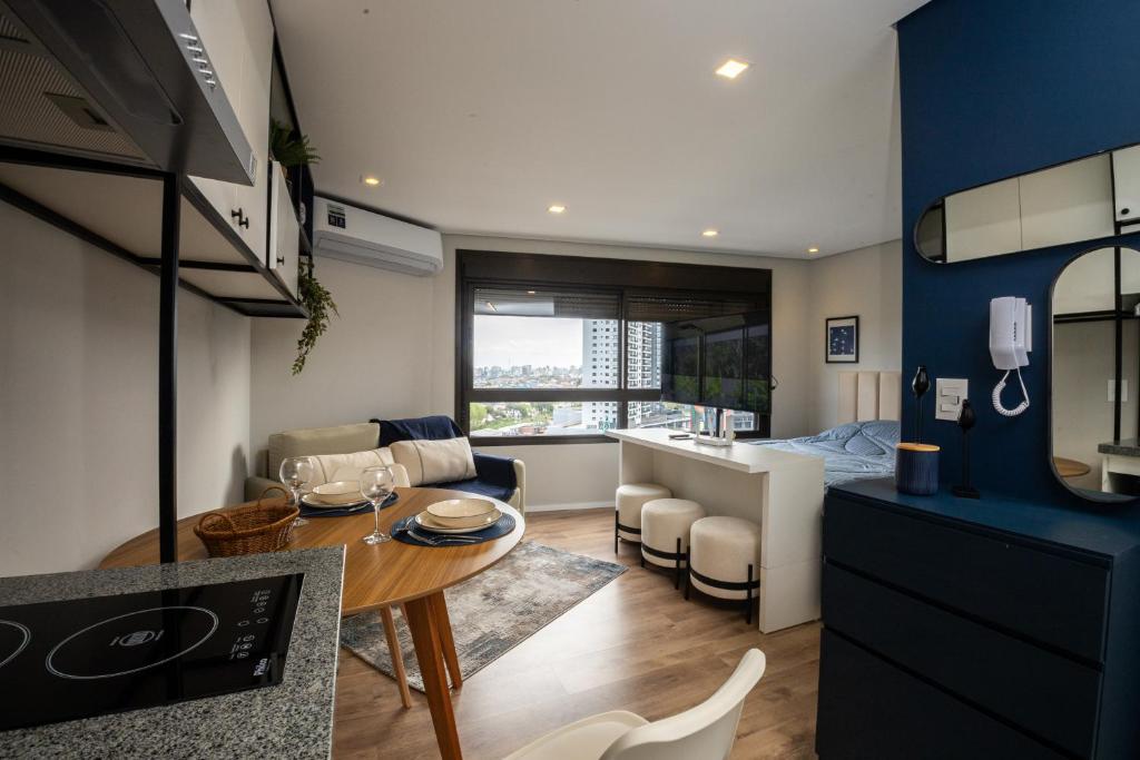 une cuisine et un salon avec une table et un canapé dans l'établissement Loft 907 Parque Una - Aurora, à Pelotas