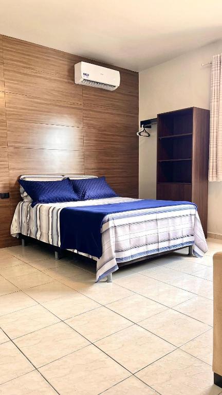 阿拉皮拉卡Loft Luxo Aconchego do Agreste的一间卧室设有一张带木墙的大床